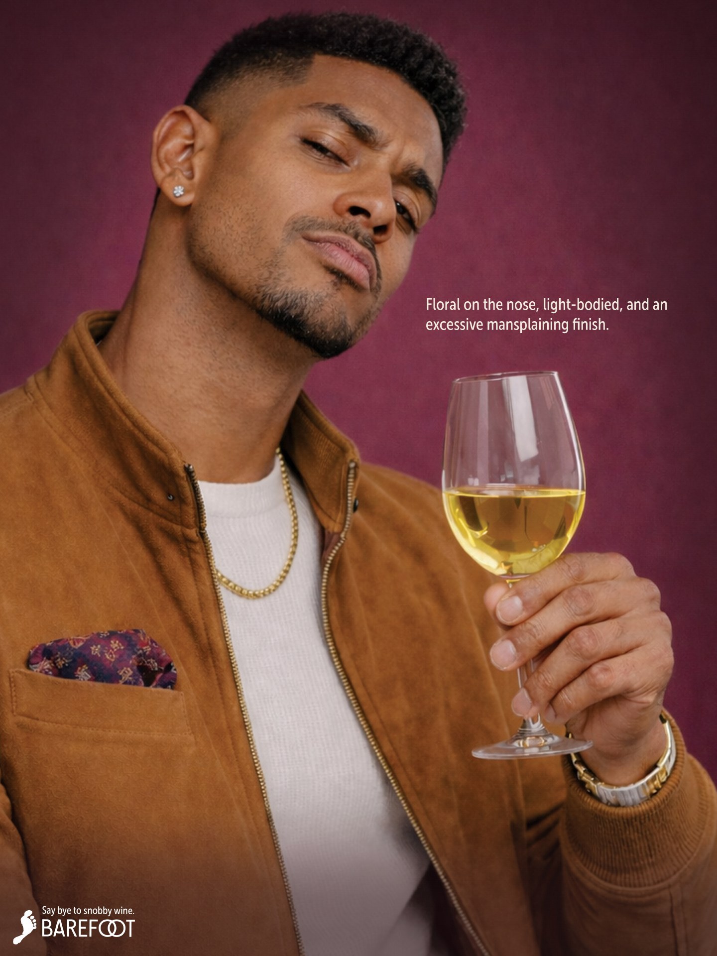 Barefoot ad: a man in a suede jacket with a gold chain holding a glass of white wine, with the line "Floral on the nose, light-bodied, and an excessive mansplaining finish."