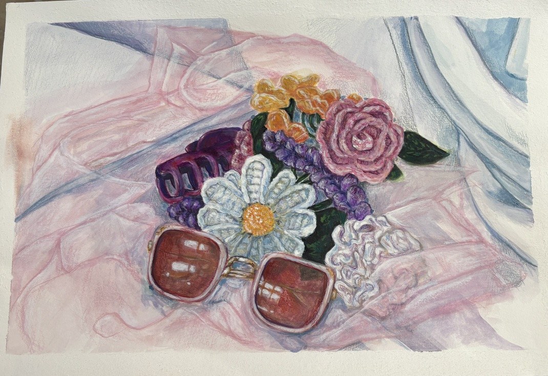 Mixed media still life of sunglasses and crocheted flowers on pink fabric.